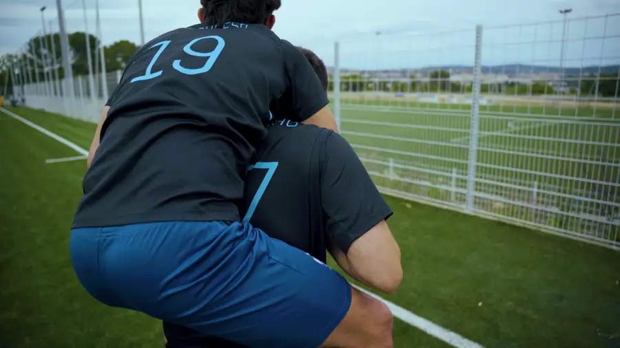 Deux joueurs en maillot FoundClub, vus de dos, sur un terrain synthétique